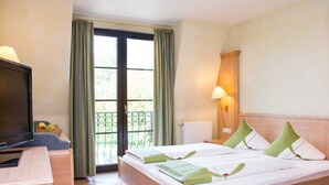 A hotel room with a bed, a desk, a television, and a window with curtains. - Standard - Double room - Hotel Casa Rustica (Rust)