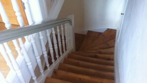 Una escalera de madera con balaustres blancos y barandilla de madera.