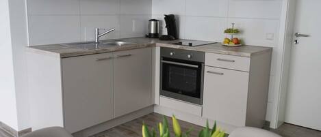 Kjøleskap, ovn og høy barnestol