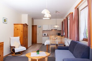 A compact living space with a sofa, dining table, and kitchenette. - Vacation apartment 2 "Stübenbach" - Haus Keller vacation apartments (Todtnau)