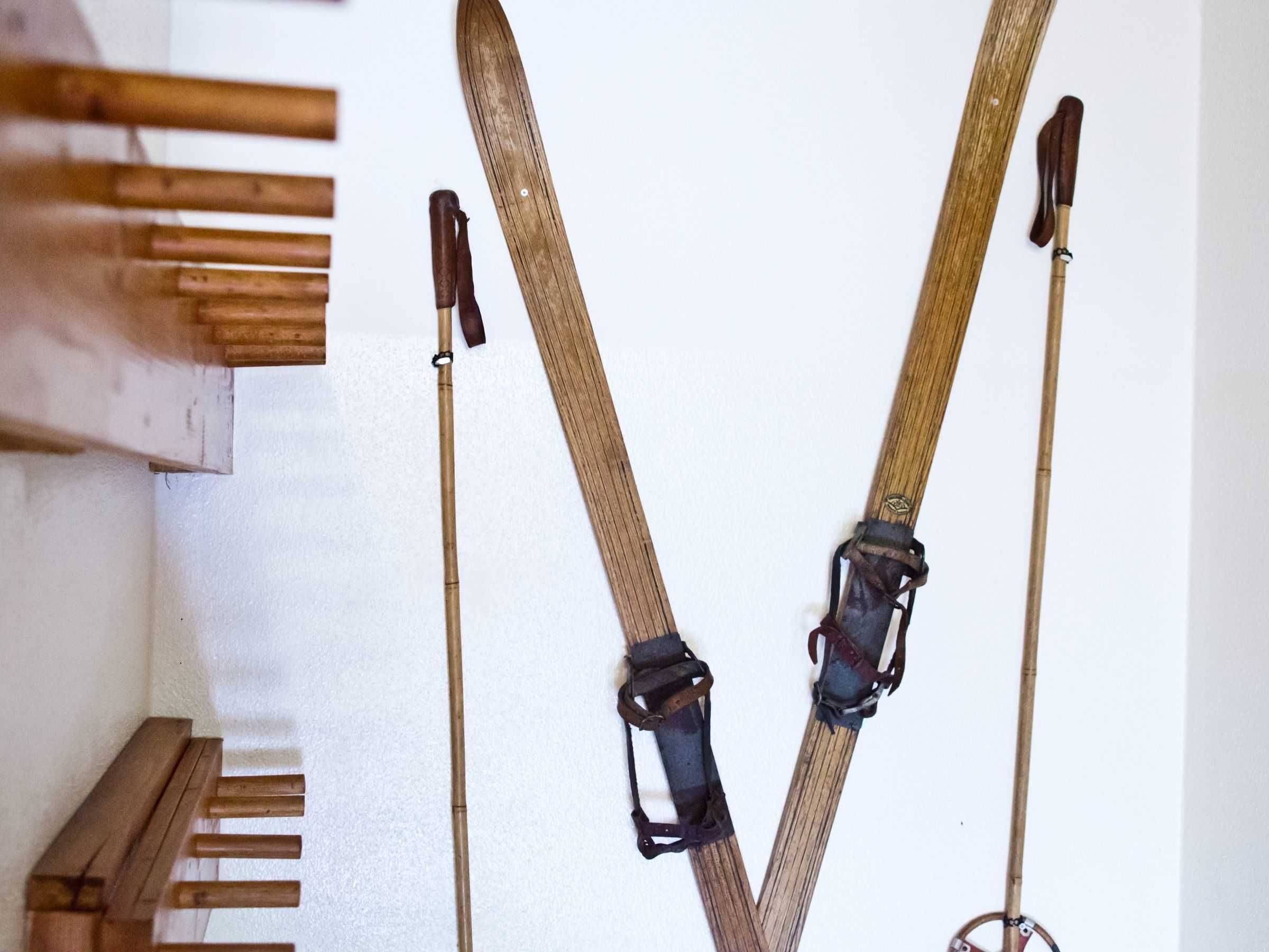 Un portaequipajes para esquíes con dos pares y un banco de madera.