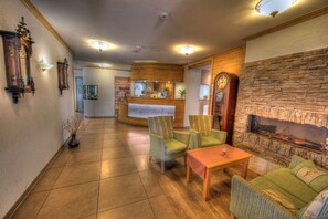A lobby with a reception desk, seating area, and a stone fireplace. - Double room comfort - Hotel-Restaurant Schwörer (Lenzkirch)