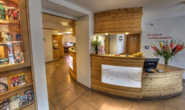 A reception desk with a wooden finish, a computer, and a welcome sign. - Double room comfort - Hotel-Restaurant Schwörer (Lenzkirch)
