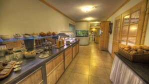 Montaje de bufé con diferentes alimentos, una estación de café y un acuario en una habitación de hotel.