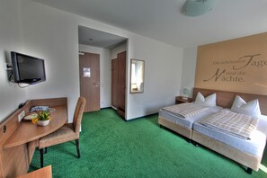 A hotel room with a desk, two beds, a mirror, and a wall with a motivational quote. - Double room comfort - Hotel-Restaurant Schwörer (Lenzkirch)
