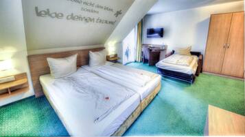 A hotel room with two beds, a TV, and a wardrobe.