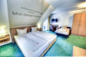 Habitación de hotel con dos camas, televisión y armario.