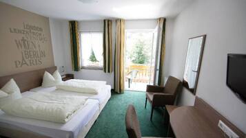 Une chambre d’hôtel avec deux lits, un bureau, une chaise, une télévision et un balcon avec des rideaux.