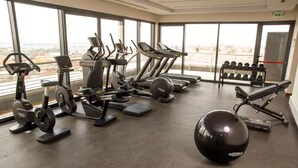 A gym with treadmills, elliptical machines, a rowing machine, dumbbells, and a medicine ball. - Airport Hotel Entebbe (Entebbe)