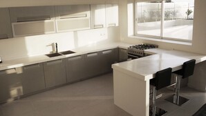 A modern kitchen with a central island, stainless steel appliances, and a large window providing natural light. - Airport Hotel Entebbe (Entebbe)