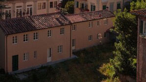 A historic town with traditional architecture, including a prominent tower and terracotta-tiled buildings. - Spacious Home with Elevator along Via Guinigi inside the Lucca Walls (Lucca)
