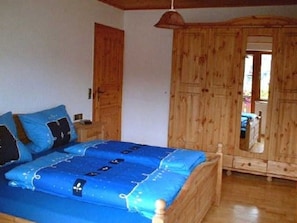 A bedroom with a wooden bed, a wardrobe, and a mirror. - Wanglerhof - vacation apartment, Kappelenblick, 2 bedrooms, 1 eat-in kitchen, max. 5 persons (Schuttertal)
