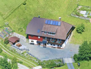 Et toetagers hus med skråtag, solpaneler og en lille tilhørende garage.