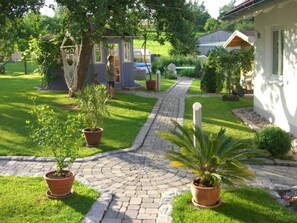 A garden pathway leading to a house with a small shed and potted plants. - Apartment 40m² type B first floor, 1 bedroom, max. 2 persons - House (Bonndorf im Schwarzwald)