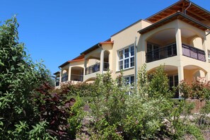 A multi-story building with balconies and large windows.
