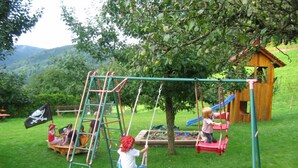 A playground with a swing set, slide, and climbing structure.