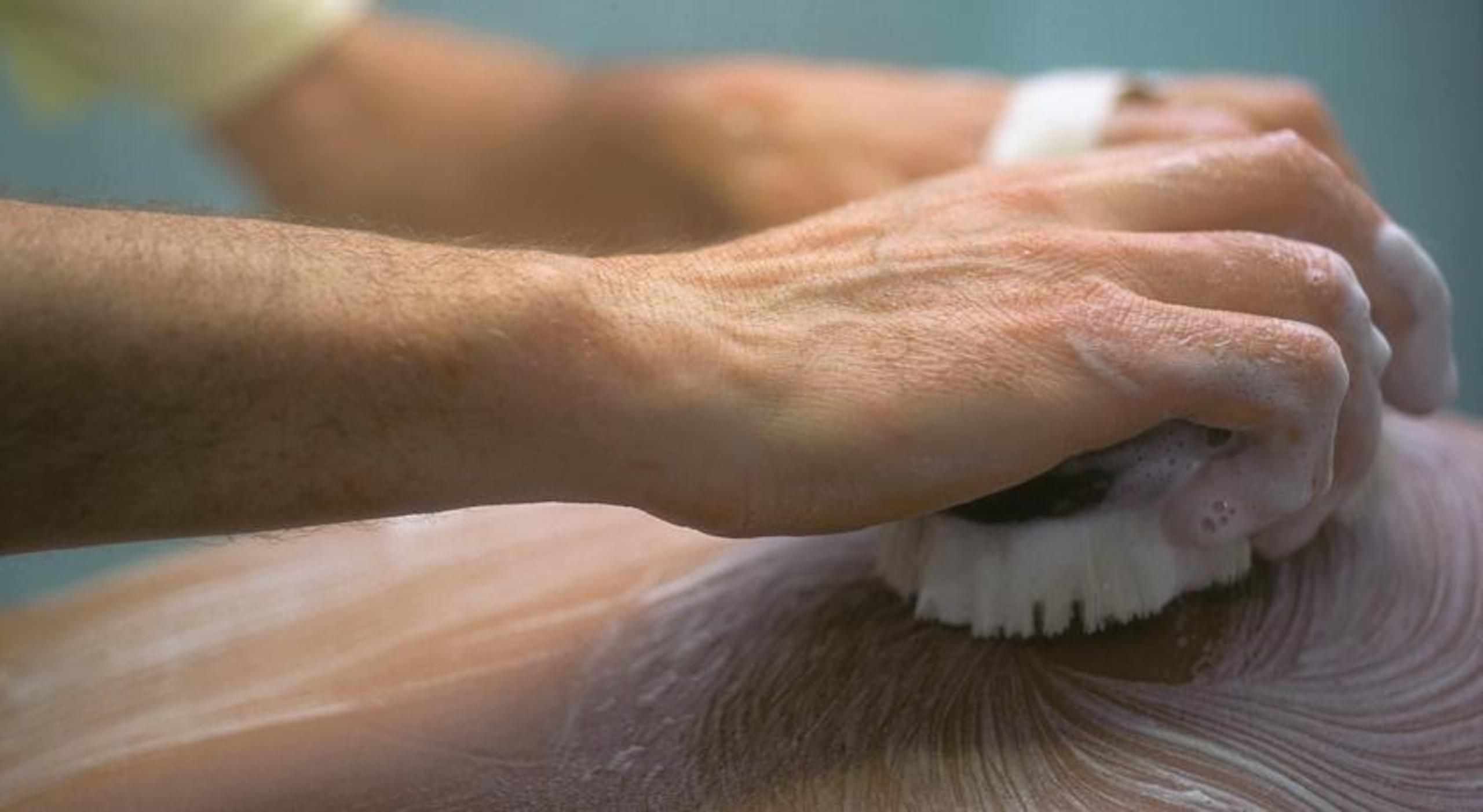 A close-up of hands performing a grooming task, likely shaving or hair care.