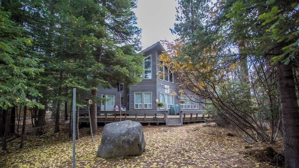 A modern house with a large rock in the foreground, surrounded by trees and fallen leaves. - McCall Retreat on Golf Course Minutes to Downtown (McCall)