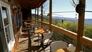 Terraza de madera con asientos exteriores y una vista panorámica de la montaña.
