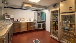 Una cocina con un refrigerador de acero inoxidable, una cafetera y un enfriador de vino.