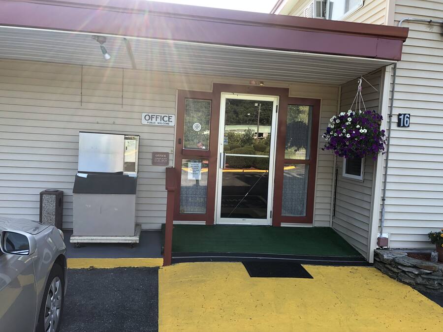 A building with a 'Public Welcome' sign, a mailbox, and a door with a glass panel.