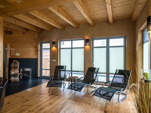 Une pièce avec un plancher en bois, une cheminée et trois fauteuils confortables.
