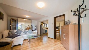 Una sala de estar moderna con sofá, mesa de centro y suelo de madera.