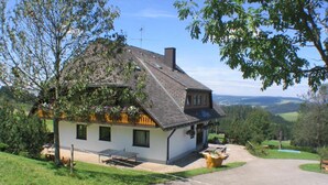 A house with a sloped roof, a chimney, and a small porch with a bench. - No4 panoramic view, 1 - 4 people - Christenmartinshäusle (Sankt Märgen)