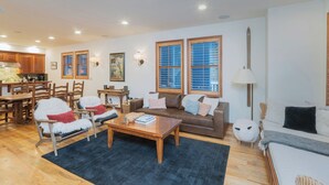 A spacious living room with a wooden coffee table, two sofas, and a dining area with wooden chairs. - SOUTH PACIFIC TOWNHOUSE- Walk to Gondola and Exquisite Mountain Views (Telluride)
