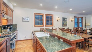 A kitchen with wooden cabinets, a granite countertop, and a built-in stove. - SOUTH PACIFIC TOWNHOUSE- Walk to Gondola and Exquisite Mountain Views (Telluride)