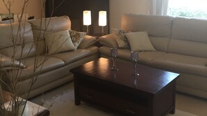 Ein Wohnzimmer mit einer Couch, einem Couchtisch und zwei Stehlampen.