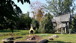 A rustic outdoor area with a wooden structure, a fire pit, and a wooden deck. - Single room (room 23) - Gästehaus EJS e. V.  Eggesin (Eggesin)