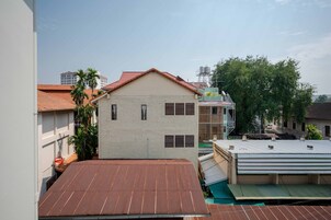 A residential building with a red-tiled roof, a white facade, and a small balcony.
