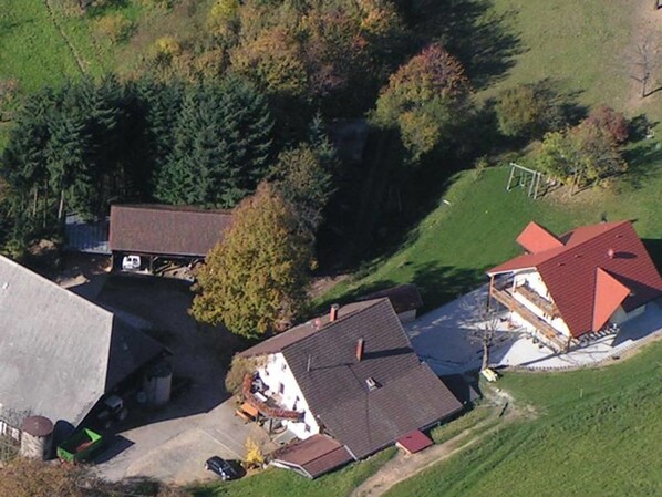 Vue aérienne d’un quartier résidentiel avec des maisons, une allée et un terrain de football.