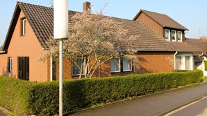 A two-story brick house with a tiled roof, a chimney, and a large white utility pole. - NR vacation apartment no. 1, 2 persons - Holiday apartment Nain (Bad Dürrheim)