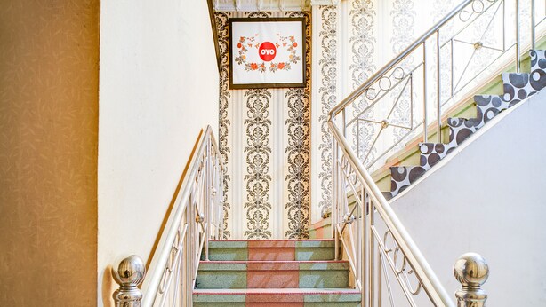 A staircase with ornate metal railings and patterned wallpaper.