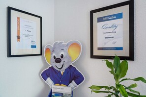 A framed certificate on a wall, a framed award on the left, and a framed award on the right. - Two-Bedroom Apartment - South Side - Pension Sieg (Rust)
