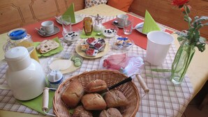 A breakfast setup with bread, pastries, and beverages on a checkered tablecloth.
