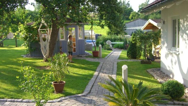 A garden pathway leading to a house with a small shed and potted plants. - Vacation apartment Hardtblick 70sqm, 2 bedrooms, max. 4 pers. - Haus Fechtig (Bonndorf im Schwarzwald)
