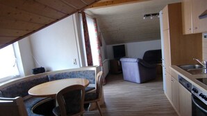 A compact kitchen with a dining area, wooden flooring, and a built-in bench with chairs. - Vacation apartment Hardtblick 70sqm, 2 bedrooms, max. 4 pers. - Haus Fechtig (Bonndorf im Schwarzwald)
