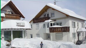 A building with a sign reading "Fechtia" and a person standing in front of a snow-covered area. - Vacation apartment Hardtblick 70sqm, 2 bedrooms, max. 4 pers. - Haus Fechtig (Bonndorf im Schwarzwald)
