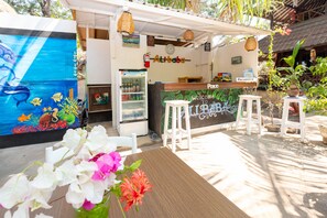 A restaurant with a mural of marine life, a reception desk, and outdoor seating.