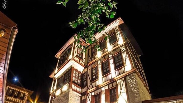 A traditional building with a stone facade, multiple windows, and a staircase leading to the entrance. - Karauzumler Konagi (Safranbolu)