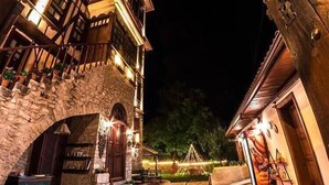 A stone building with a wooden staircase and a stone archway leading to a door. - Karauzumler Konagi (Safranbolu)