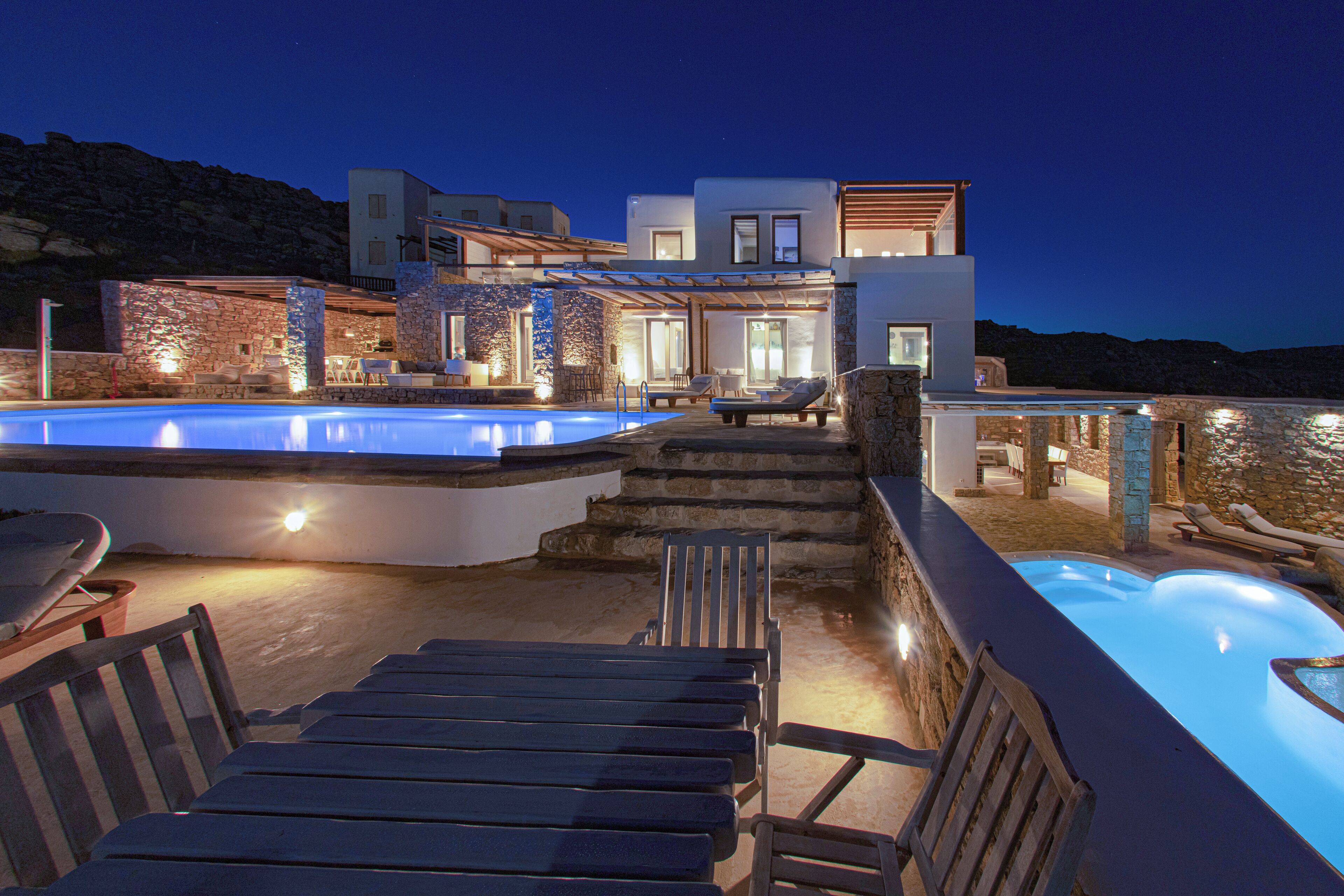 Um resort moderno com piscina, área de estar externa e fachada de pedra.