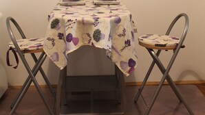 A dining table with a floral tablecloth, two chairs, and a wall clock. - Studio Zsofia in Budapest (Budapest)