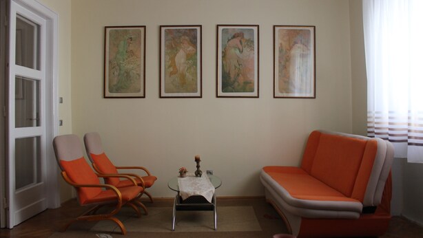 A living room with a sofa, two armchairs, a small table with a candle, and four framed artworks on the wall. - Studio Zsofia in Budapest (Budapest)