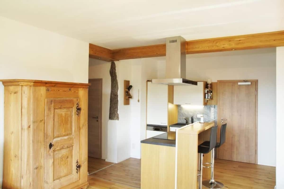 Eine Küche mit Holztischplatte, einem Herd und einer Bar mit zwei Stühlen.