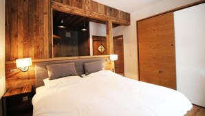 A bedroom with a wooden headboard, a large mirror, and two bedside lamps. - Alpengasthof Krische (Sankt Georgen am Kreischberg)