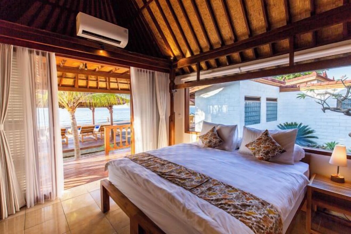 Un dormitorio con cama, cortinas, una ventana y vistas al exterior.